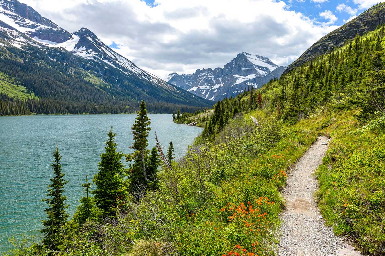 Path along lake with mountains in the distance