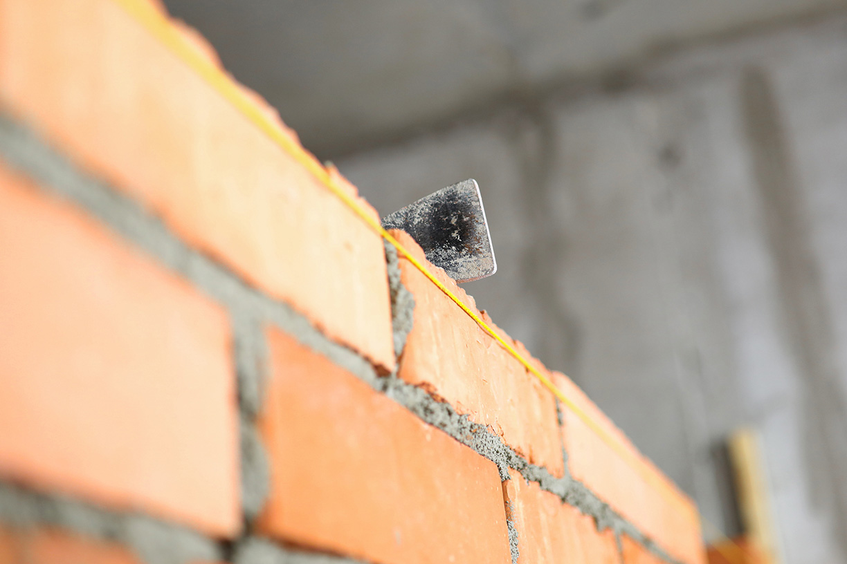 Mallet lying on top of brick wall as building and renovation