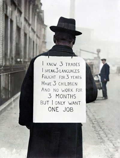 Depression era man on street wears sign on his back that reads